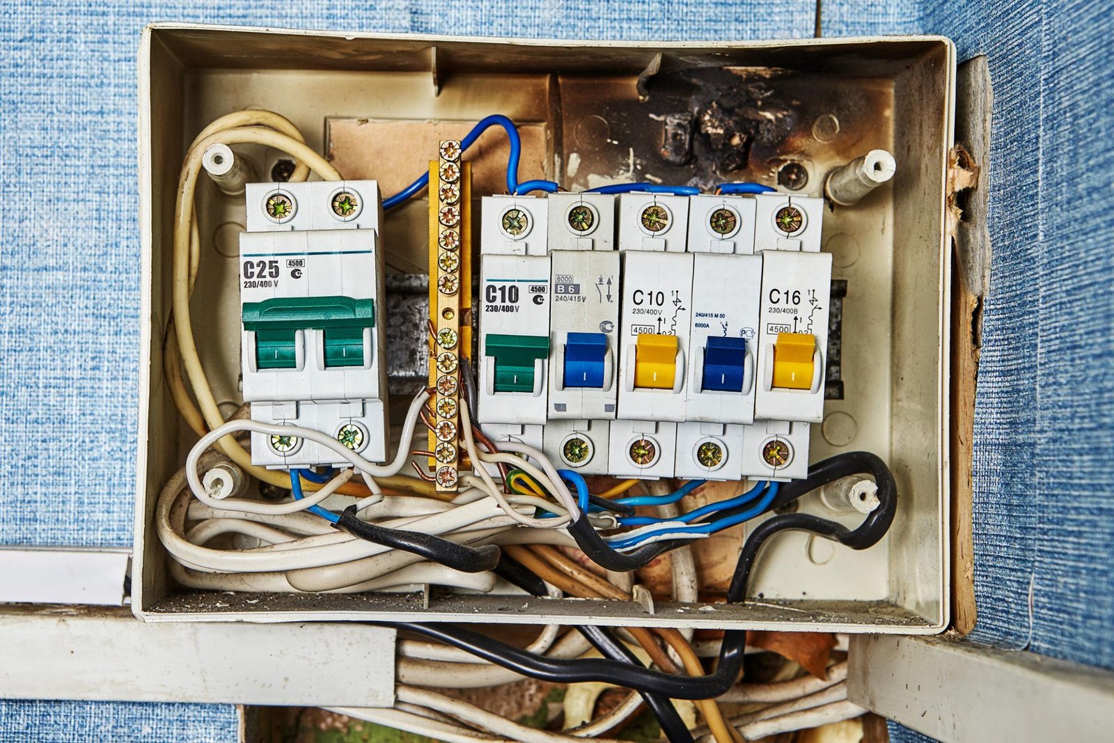 Villanyszerelő egy régi lakás elektromos elosztótábláját ellenőrzi